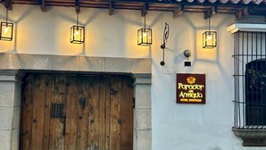 A hotel entrance with a wooden door, hanging lanterns, and a sign for 'Paradox de Annique Hotel Boutique'. - Parador de Antigua (Antigua Guatemala)