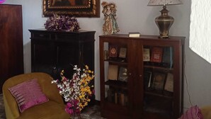 A living room with a large framed painting, a small statue, a lamp, and two sofas. - Parador de Antigua (Antigua Guatemala)