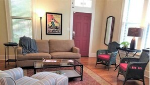 Un salon comprenant un canapé, des fauteuils, une table basse et un tapis.