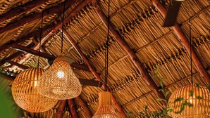 A thatched roof structure with hanging woven light fixtures. - Hotel Málaga Managua (Managua)
