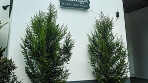 A hotel sign with the name "Málaga Hotel Boutique" and a logo featuring two glasses. - Hotel Málaga Managua (Managua)