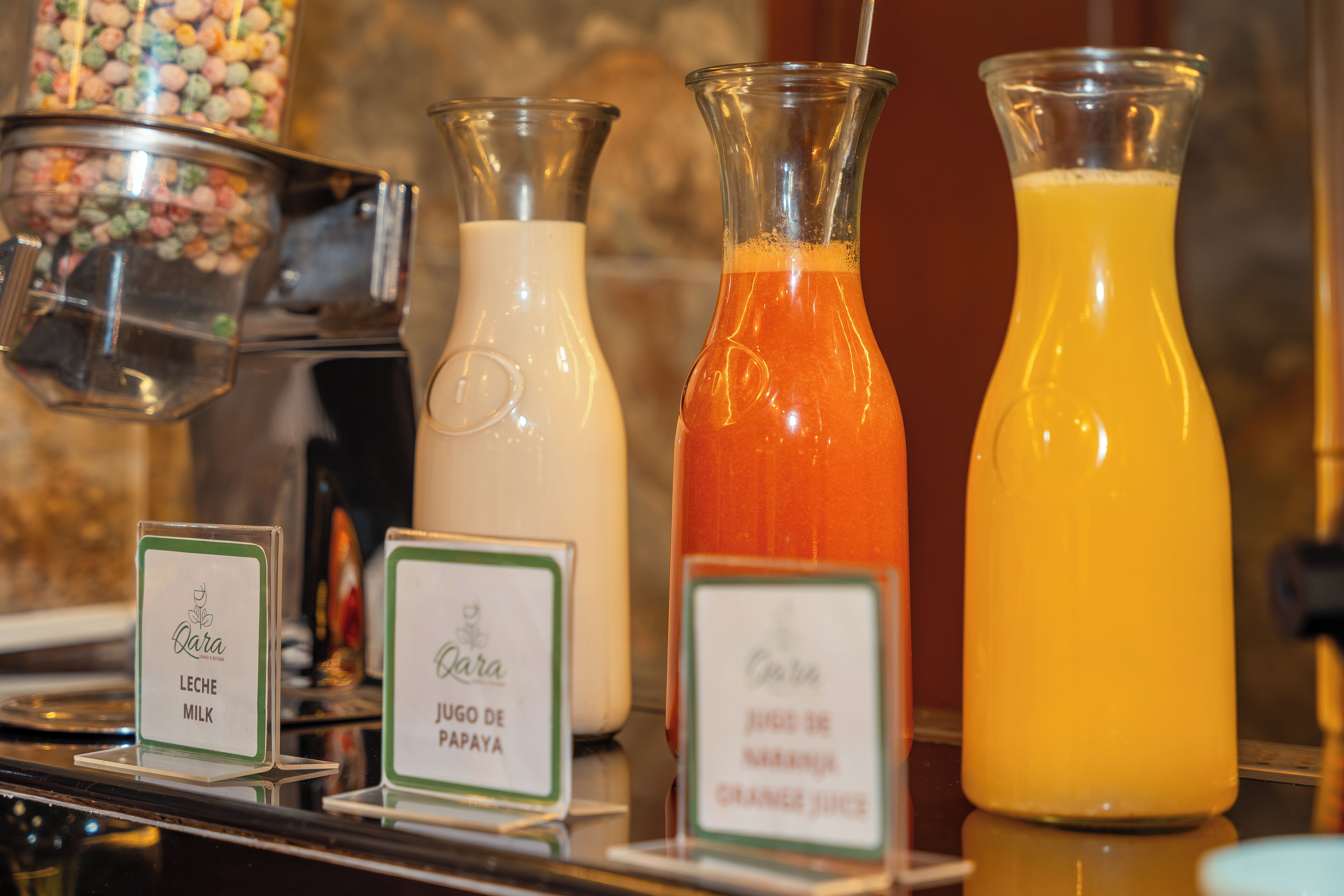 A selection of beverages including milk, papaya juice, and orange juice, each labeled with the brand 'Qara'.