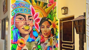 A vibrant mural with floral and animal motifs, a mirror, and a wooden door. - MONTREAL MAGDALENA HOTEL  (Lima)