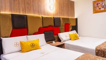 Ein Hotelzimmer mit zwei Betten, jeweils mit weißer Bettwäsche und gelben Kissen, einem Holz-Kopfteil und einem kleinen Tisch dazwischen.
