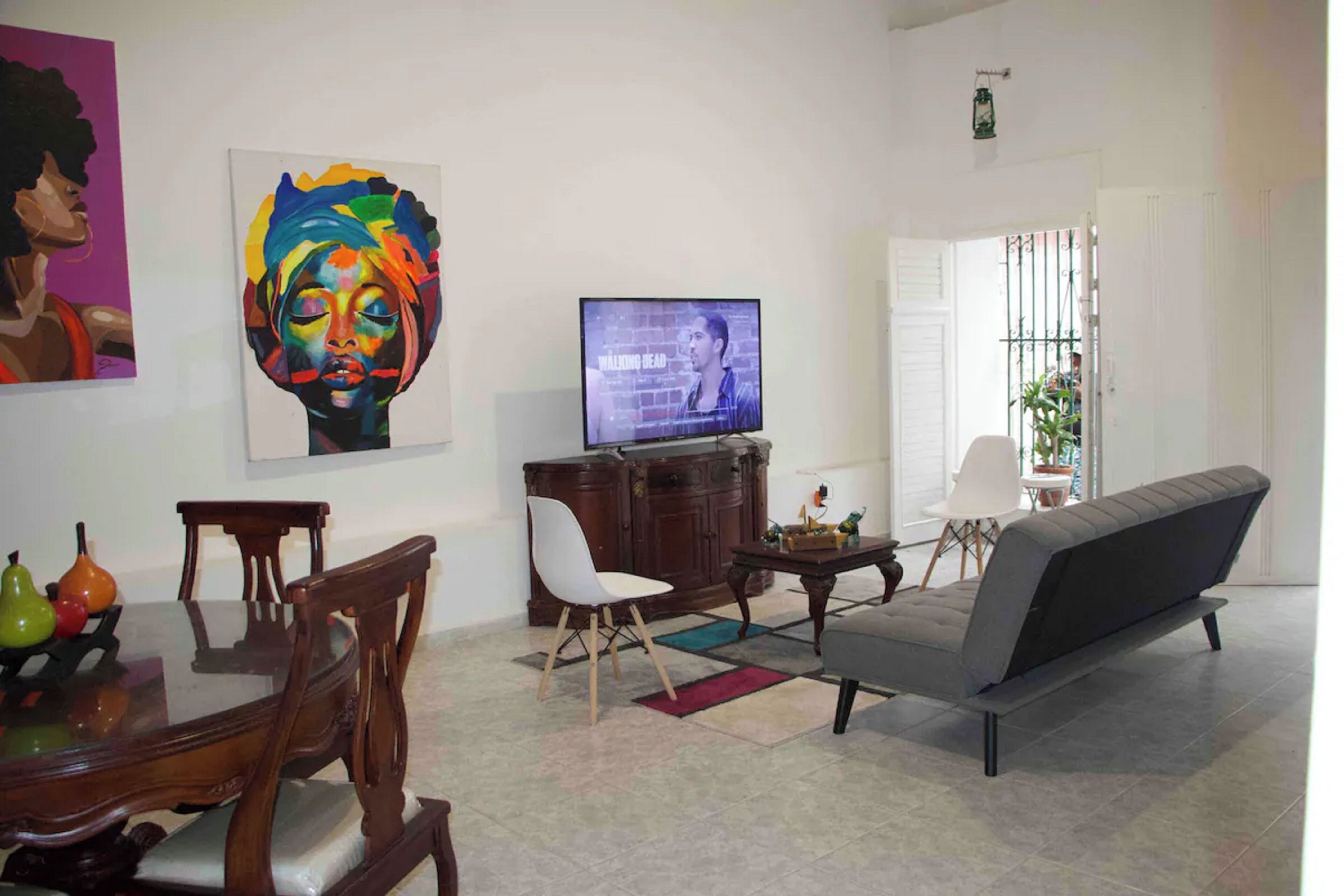 A modern living room with a dining table, sofa, and TV.