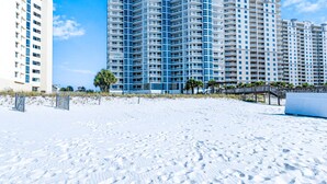 A beachfront hotel with multiple high-rise buildings, sandy beach, and a wooden walkway. - Palacio 805 | Beachfront | Beachside & Indoor Pool, Hot Tub | My Beach Getaways (Pensacola)