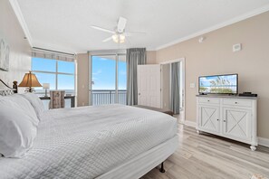 A bedroom with a bed, a television, a ceiling fan, and a view of the outdoors. - Palacio 1706 | Oceanfront, Resort Amenities | My Beach Getaways (Pensacola)