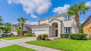 A residential house with a garage, a driveway, and well-maintained lawn.