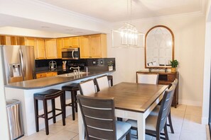 Enjoy cooking in this kitchen with a central island, bar stools, refrigerator, and oven.