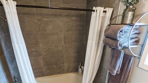 Un baño con bañera, inodoro y cortina de ducha.
