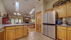 A spacious kitchen with wooden cabinets, a large island, and a built-in refrigerator.
