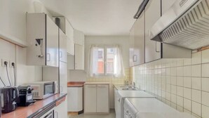 Cocina compacta equipada con microondas, tostadora y lavadora.