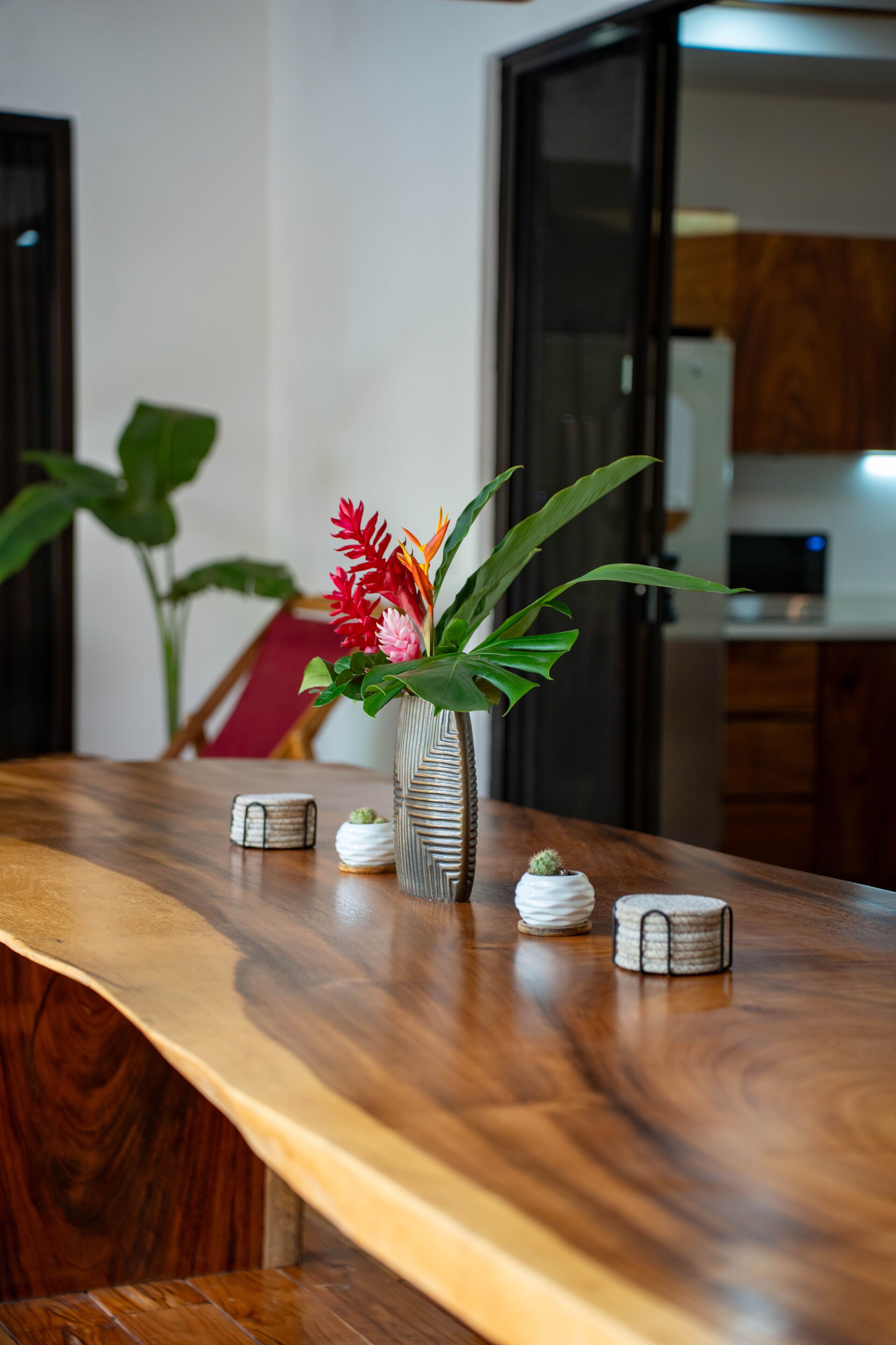 Un tavolo di legno con un vaso di fiori e due piccoli oggetti decorativi.