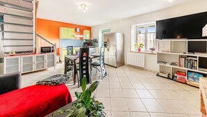 Un espacio habitable compacto con kitchenette, comedor y televisor.
