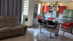 A modern living room with a sofa and two bar stools.