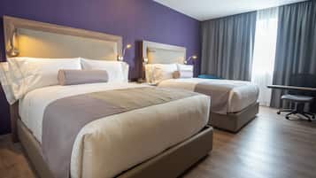 Una habitación de hotel con dos camas, un escritorio y una silla.