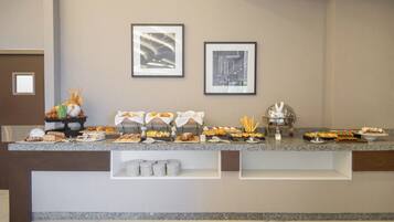 Disposição de buffet com diversos alimentos e um interior limpo e moderno.