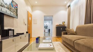 Un salon moderne avec un canapé, une table basse et un coin cuisine à l’arrière-plan.