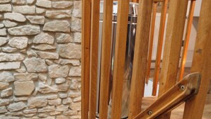 A wooden staircase with a stone wall background.