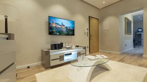 A modern hotel lobby with a flat-screen TV mounted on the wall, a reception desk, and a glass coffee table. - Liberty -32 Two-Bedroom Deluxe Apartment (Luxembourg)