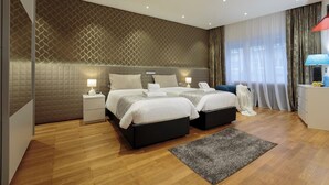 A modern hotel room with two beds, a small desk, a lamp, and a large window with curtains. - Liberty -32 Two-Bedroom Deluxe Apartment (Luxembourg)