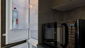 Una cucina compatta con frigorifero e forno a microonde integrati.