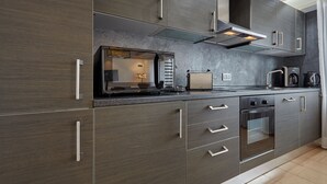 Una cucina moderna con elettrodomestici in acciaio inossidabile, forno integrato e microonde.