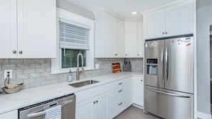 A kitchen with white cabinets, stainless steel appliances, and a window with blinds. - HOTTUB! private outdoor spaces-WALK downtown and MU. PETS OK Top Notch finishes (Columbia)