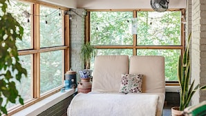A cozy bedroom with a bed, large windows, and a fan. - HOTTUB! private outdoor spaces-WALK downtown and MU. PETS OK Top Notch finishes (Columbia)