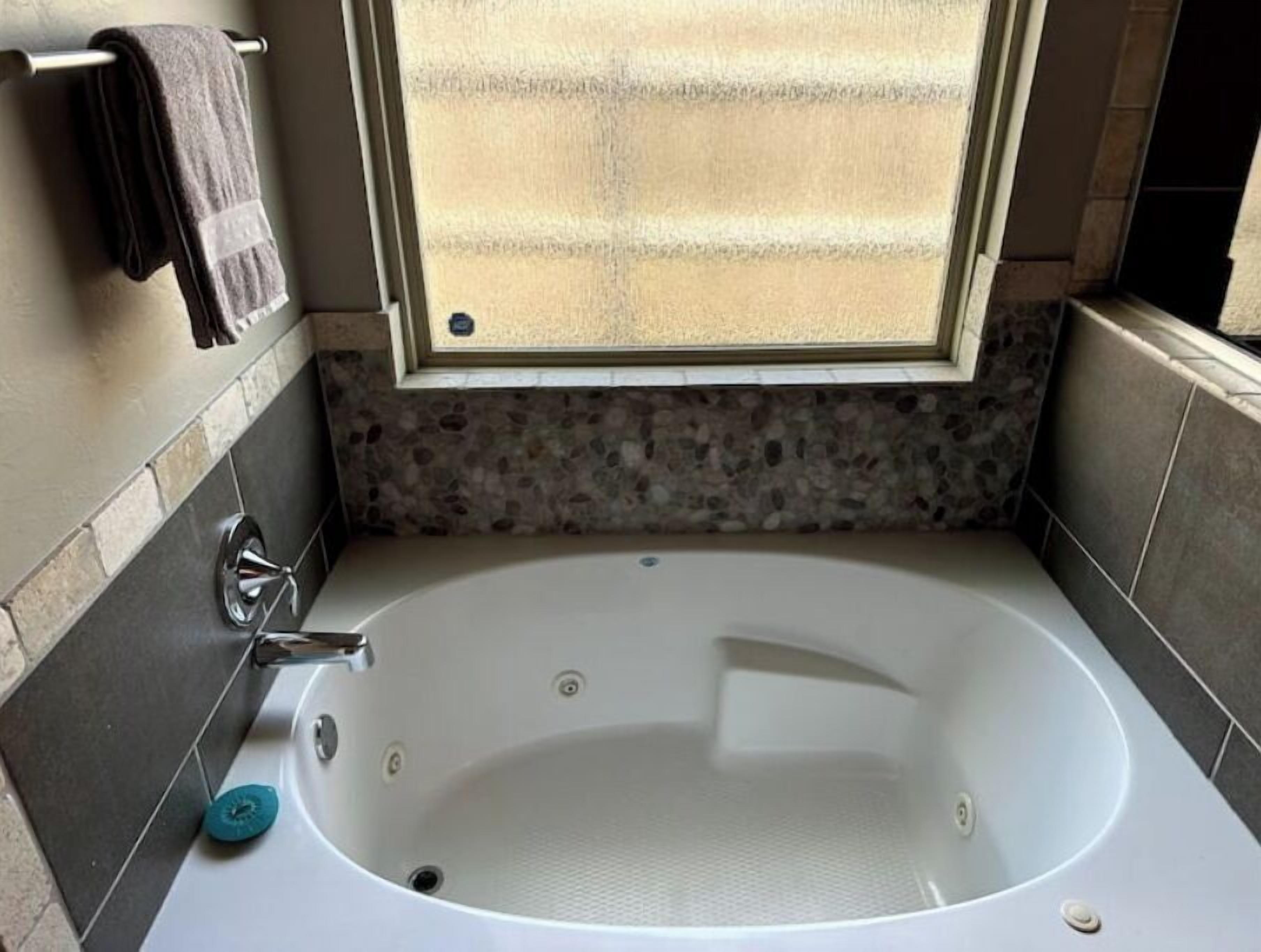 Une salle de bain avec une baignoire sur pieds, une fenêtre et un porte-serviettes.