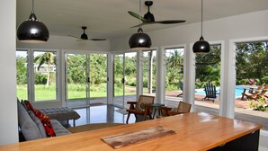 Un'ampia stanza con un grande tavolo in legno, diverse sedie e una ventola a soffitto.