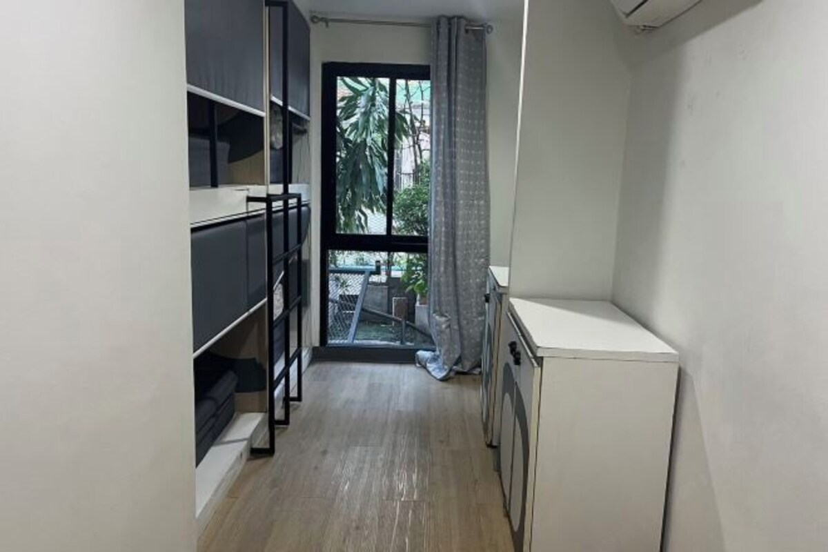A compact kitchen with a built-in stove, a small countertop, and a view of the outside through a glass door.