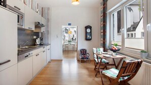 Una cocina moderna con comedor, suelo de madera y vistas por una ventana.