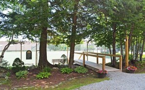 A wooden deck with a bench, surrounded by trees and a fence. - OKEMO WINTERPLACE Best Location, Ski-In/Ski-Out 4BR/3BATH + LOFT.  Spacious. (Ludlow)