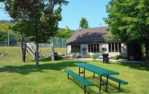 A picnic area with a table and benches, a small building with a porch, and a fenced area with a staircase. - OKEMO WINTERPLACE Best Location, Ski-In/Ski-Out 4BR/3BATH + LOFT.  Spacious. (Ludlow)