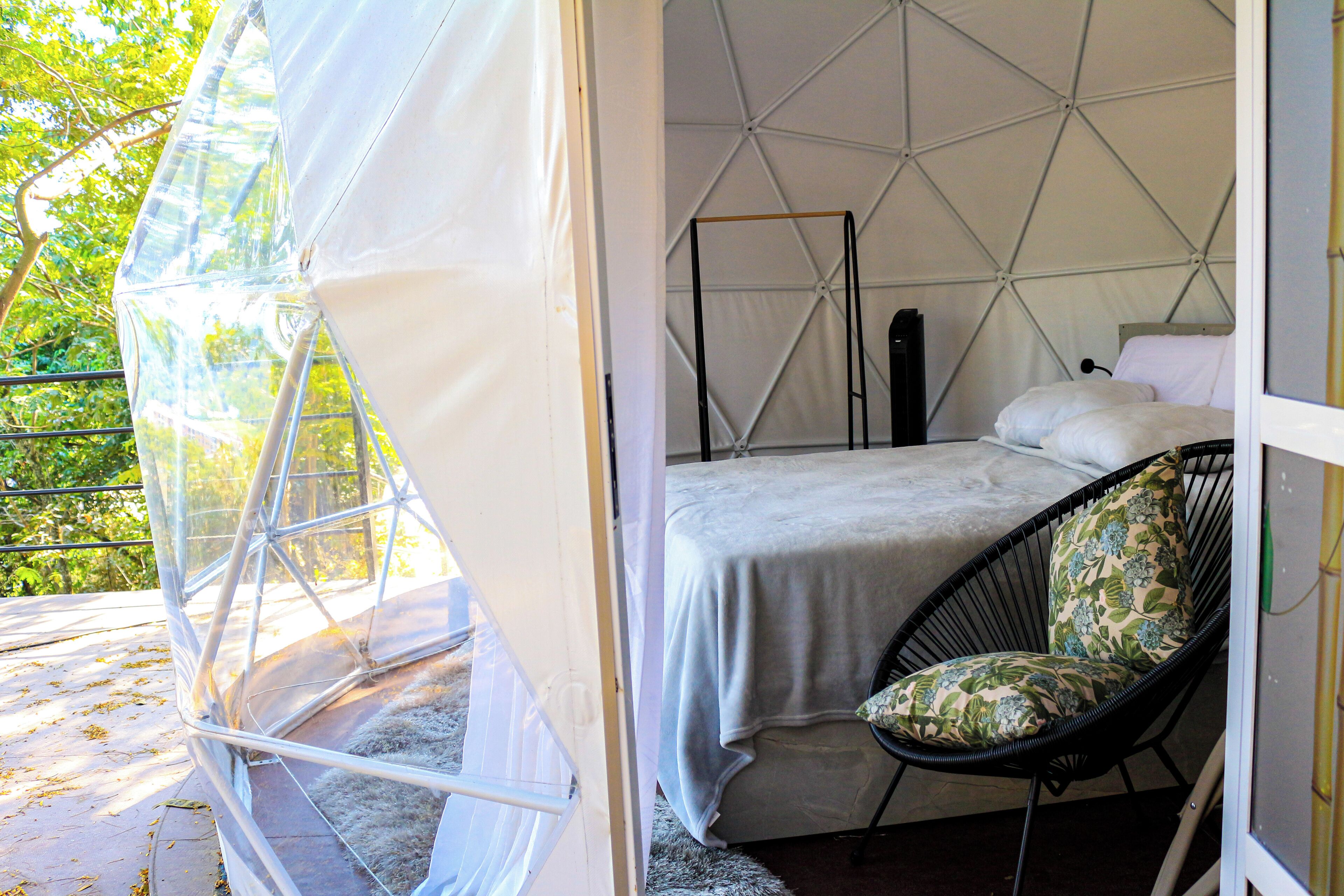 Un alloggio in tenda con un letto, una sedia e un tavolino.
