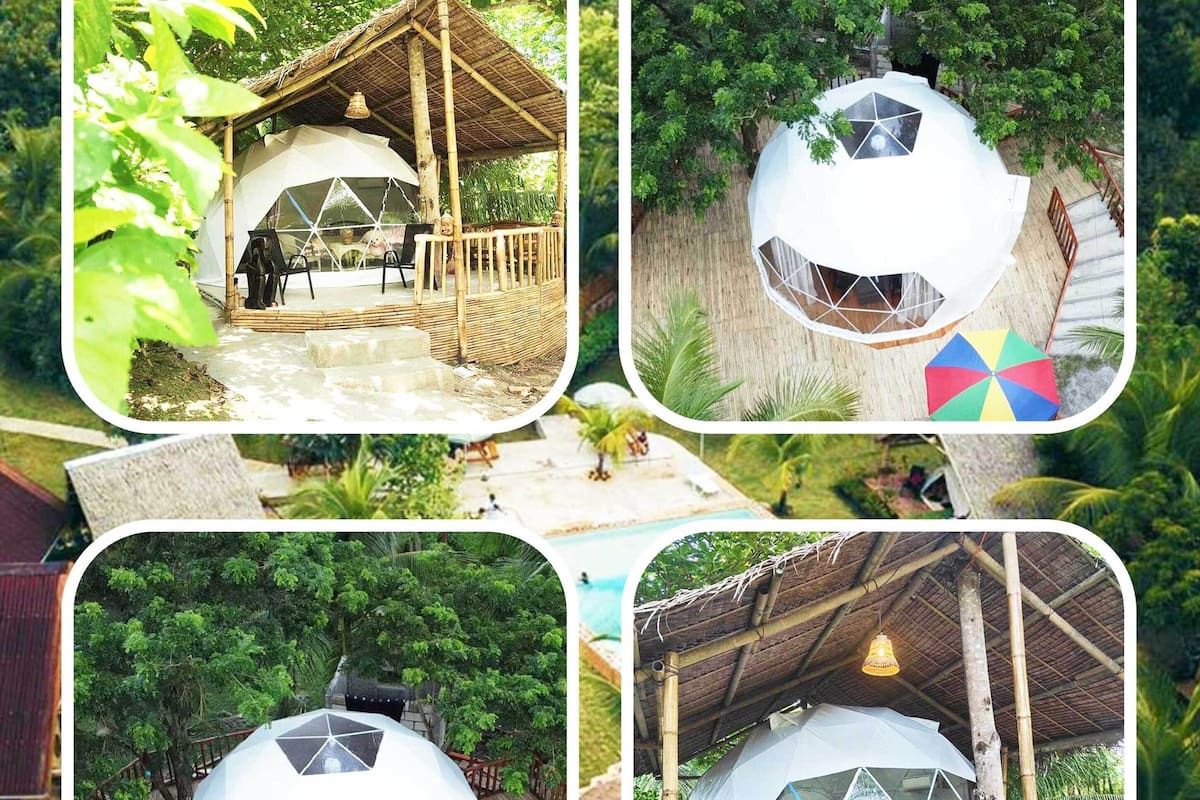 A series of geodesic dome structures with bamboo railings, surrounded by lush greenery.