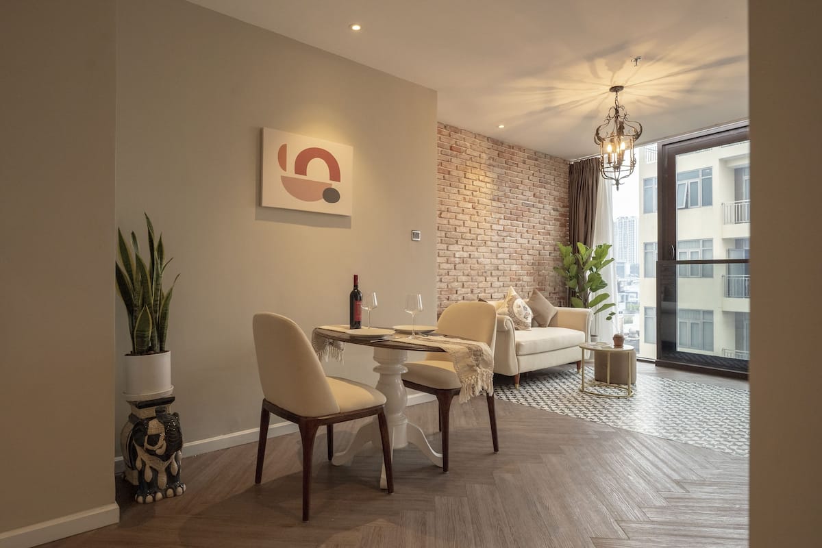 Ein modernes Wohnzimmer mit Essbereich, einer Ziegelwand und einem großen Fenster.