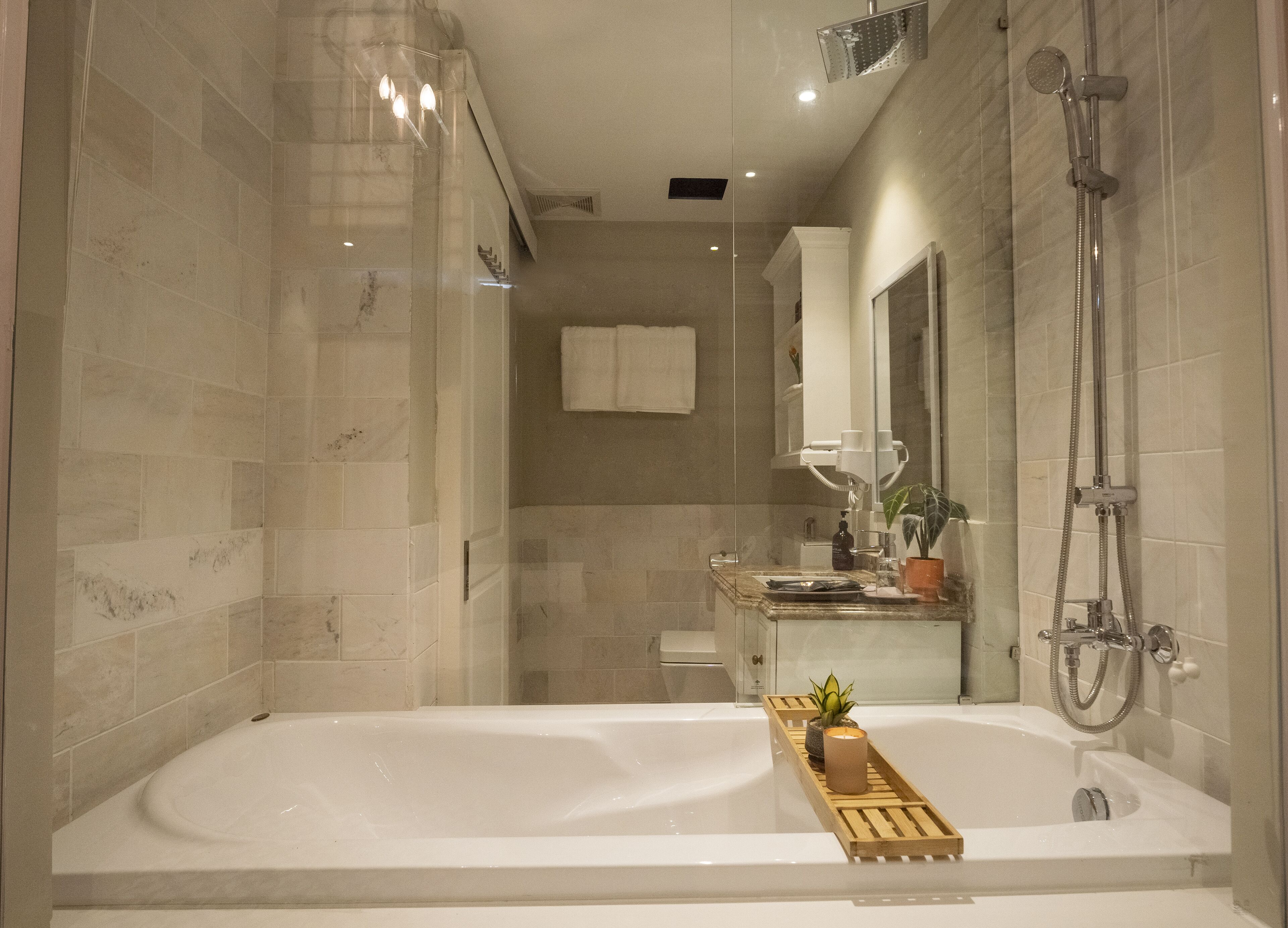 Un baño moderno con una bañera grande, una ducha y un tocador con espejo.