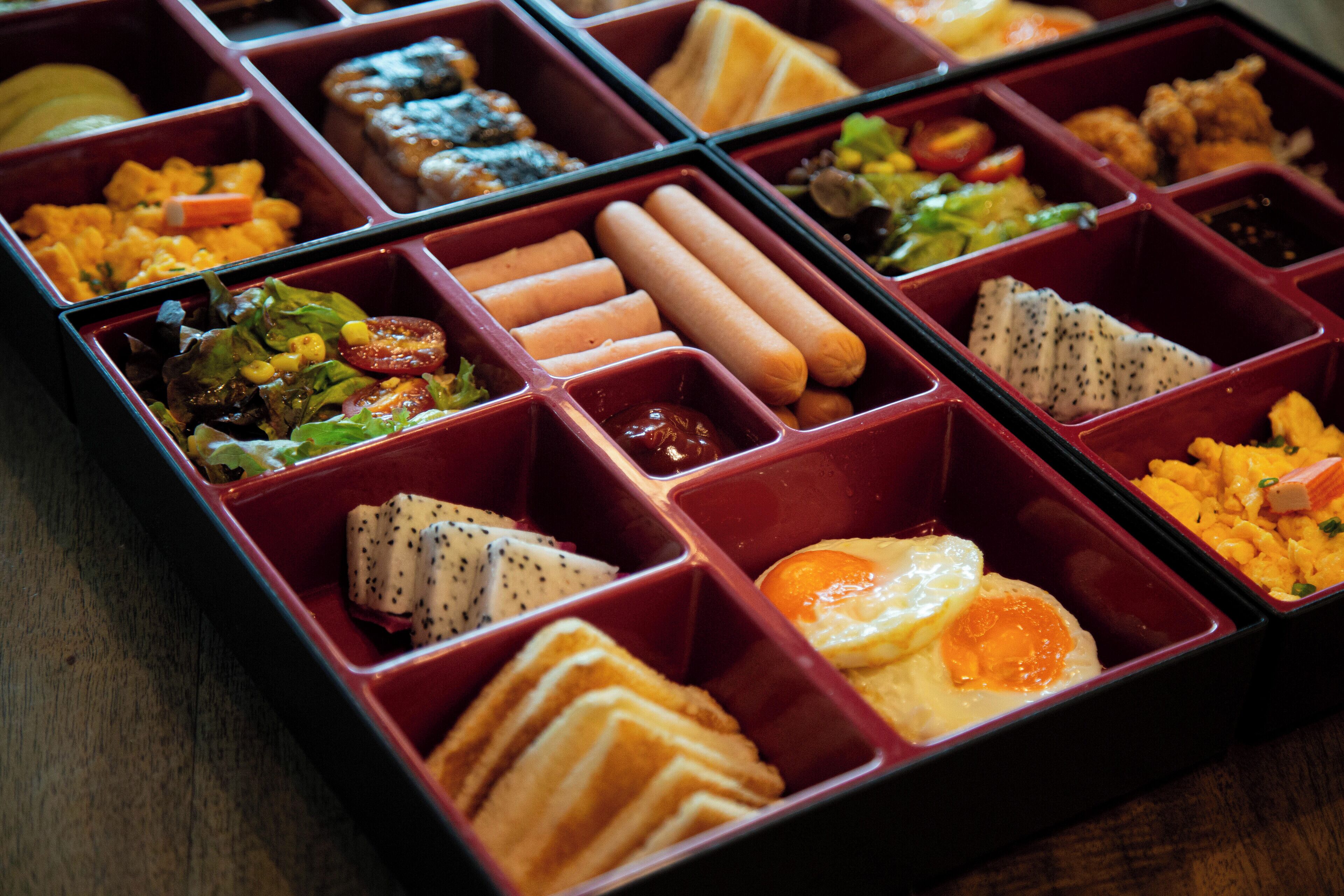A meal with various food items in separate compartments.