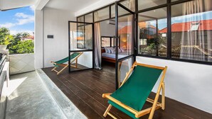 A balcony with wooden flooring and two green folding chairs. - Berawa Factory Upstairs (Canggu)