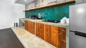 A modern kitchen with a wooden countertop, a stainless steel refrigerator, and a teal backsplash. - Berawa Factory Upstairs (Canggu)