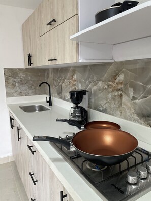 Fridge, coffee/tea maker, cookware/dishes/utensils, dining tables