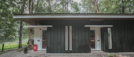 Un edificio moderno con dos amplias puertas de cristal y un camino de grava.