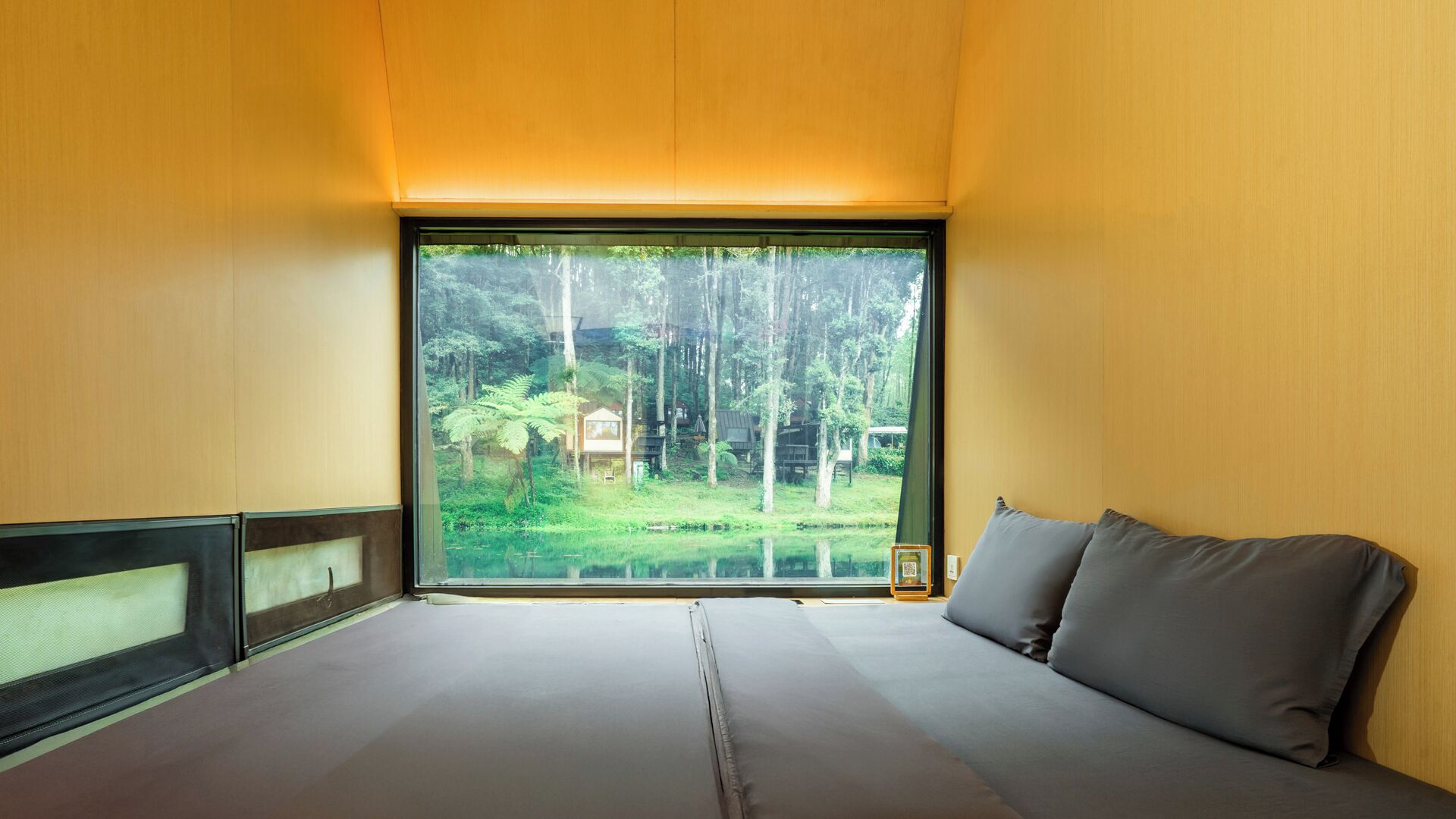 Ein Zimmer mit einem großen Fenster und Blick auf ein bewaldetes Gebiet.
