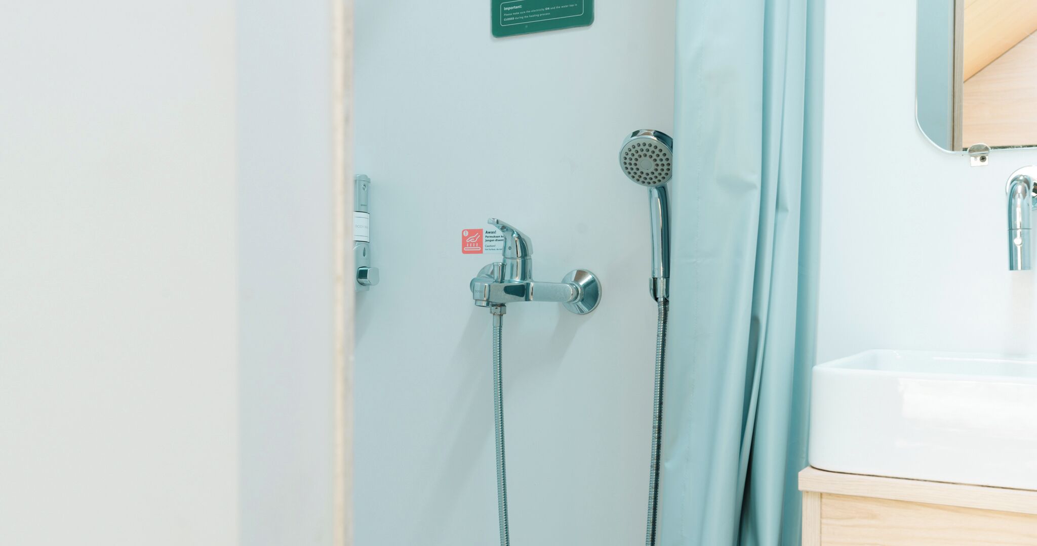 A bathroom with a shower, a sink, and a mirror.