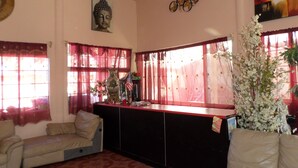A living room with a sofa, a decorative vase, and a Buddha statue on the wall. - HOSPEDAJE BARATO MI CASITA DE COLORES (Tijuana)