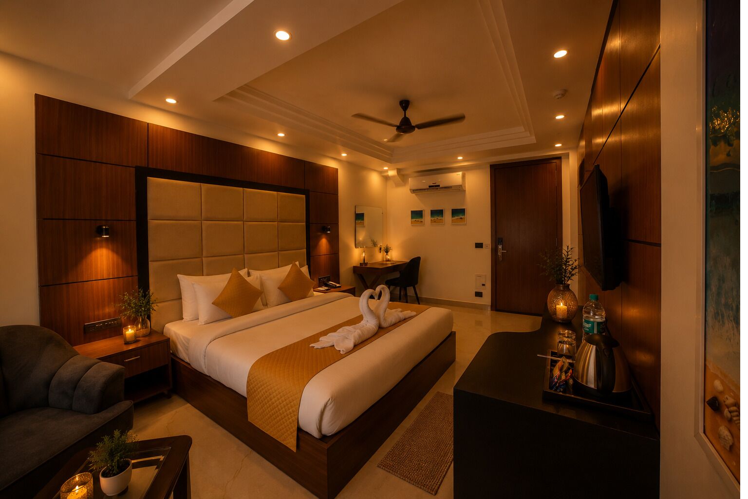A modern hotel room with a large bed, a desk, a chair, a TV, and a ceiling fan.