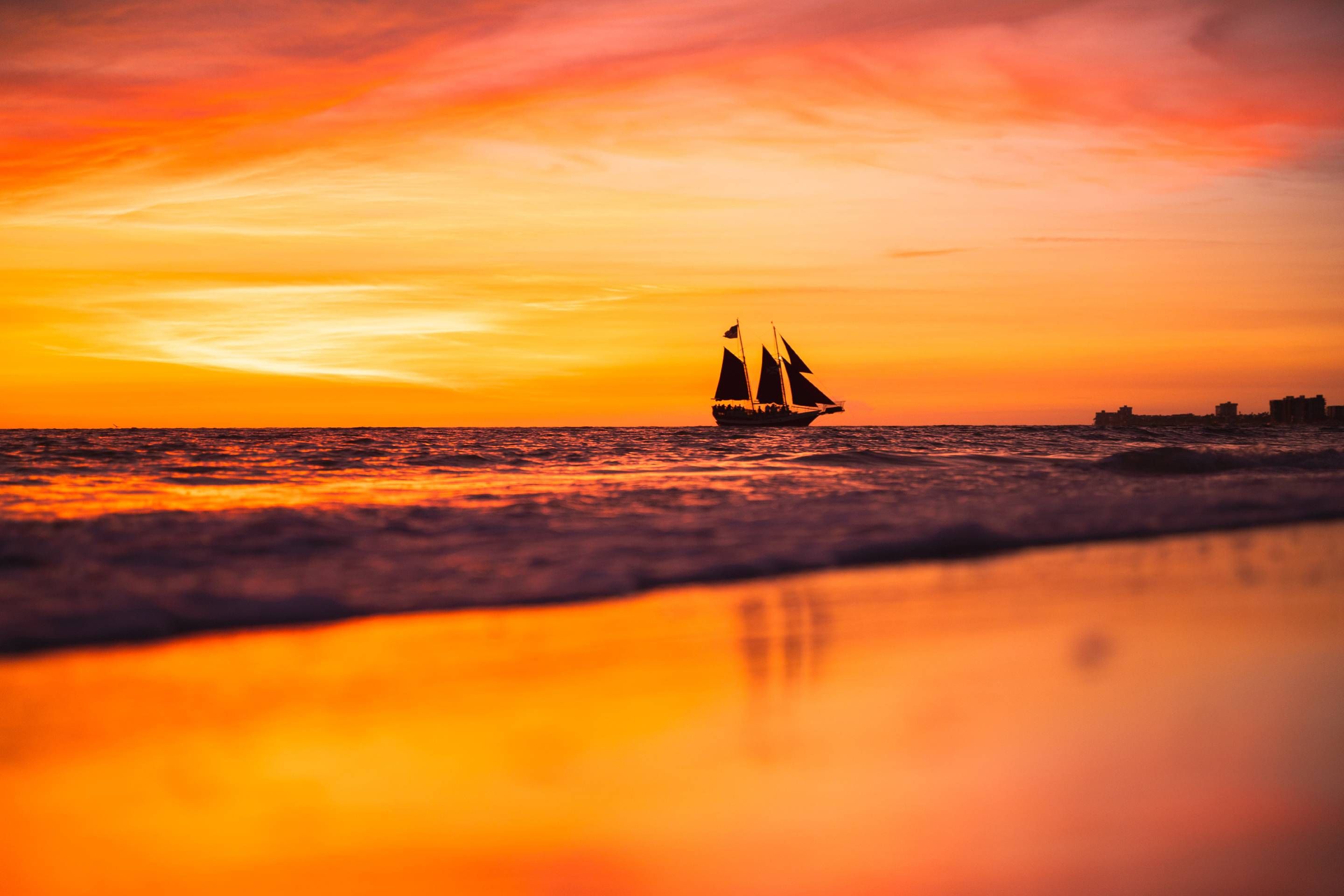 A sailboat on calm waters during sunset.