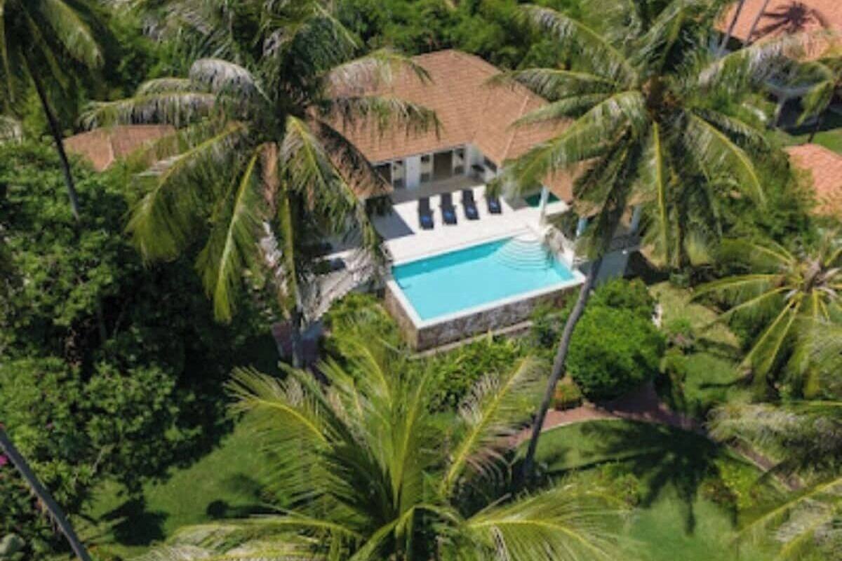 A resort with a swimming pool surrounded by palm trees.